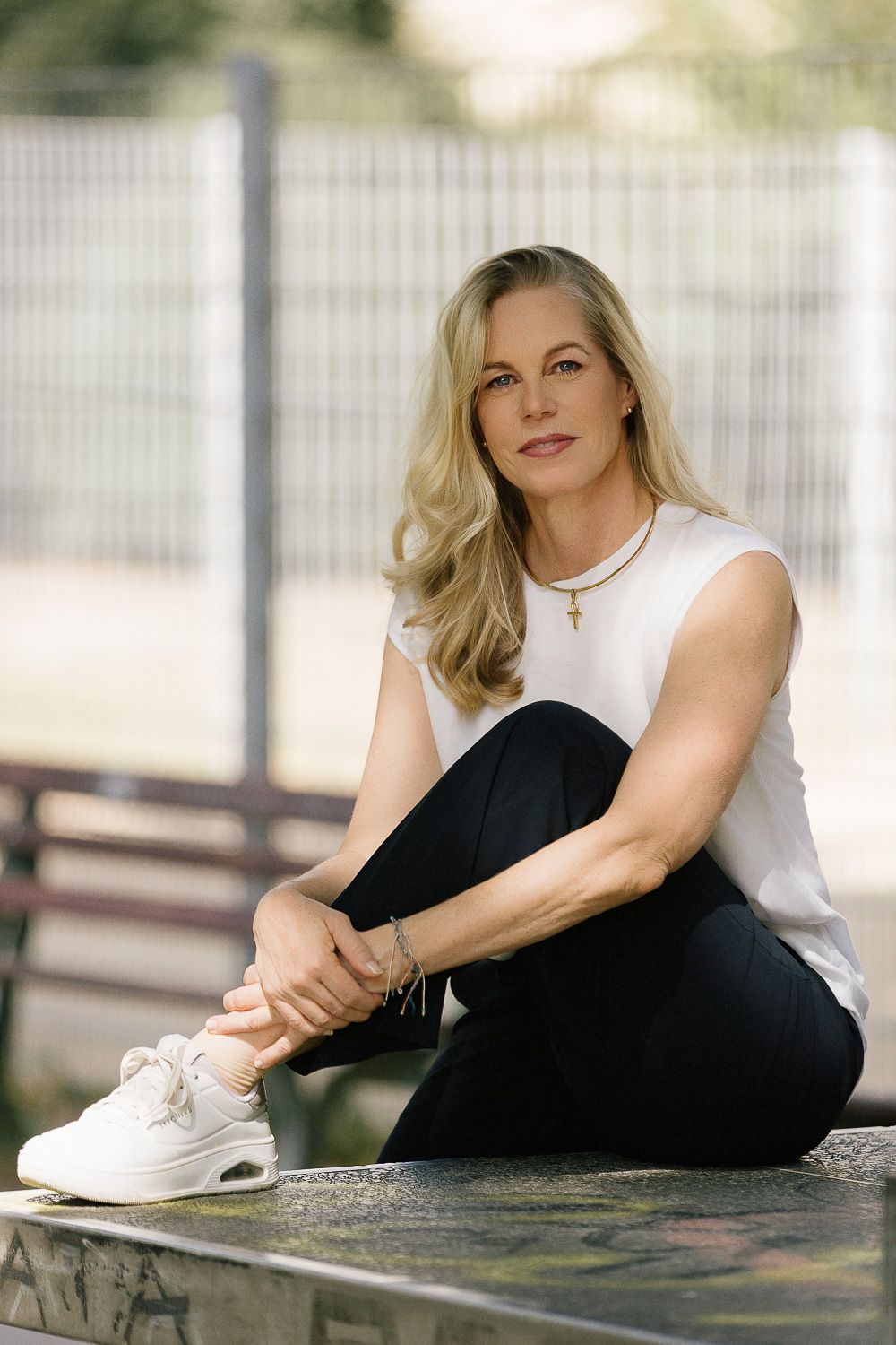 lockeres professionelles Portrait einer selbstständigen Frau auf Tischtennisplatte sitzend in Frankfurt. Businessfotografie