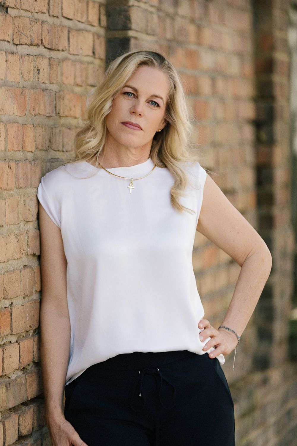 ausdrucksstarkes professionelles Portrait einer blonden Frau vor Mauer. Selbstständige freie Rednerin People-Fotografie