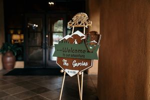Decorative wooden welcome signs and name plaques arranged in a rustic style.