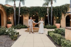 Panoramic view of an elegant Spanish-style courtyard wedding venue with stone walkways and manicured gardens.
