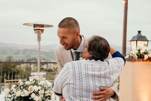Wedding couple dancing together with mountain landscape view in background.