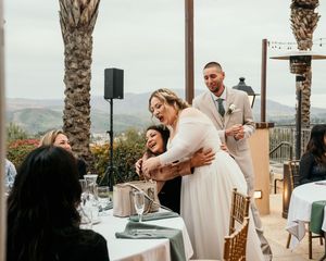 Wedding reception venue with palm trees and dining tables set up for celebration.