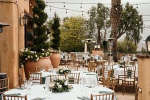 Wedding reception venue with rustic wooden chairs and string lights creating an intimate outdoor atmosphere.