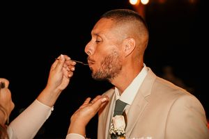 Wedding guests dancing and celebrating at a reception with dramatic lighting and festive atmosphere.