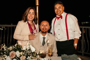 Wedding reception guests enjoying dinner and conversation at outdoor venue.
