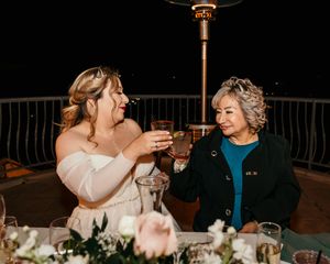 Candlelit wedding reception tables set up outdoors at night with string lights.