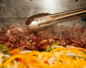 Close-up of melted cheese and meat toppings on a gourmet dish.