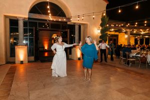 Outdoor courtyard reception space decorated with string lights and Spanish colonial architecture at dusk.