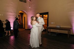 Wedding couple sharing their first dance in a dimly lit reception venue.