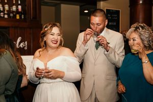 Wedding reception guests dancing and socializing in an elegant indoor venue.