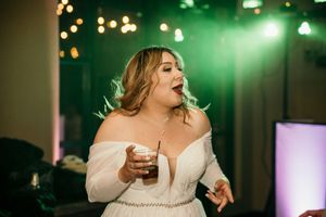 Wedding celebration with green ambient lighting and bokeh effects in the background.