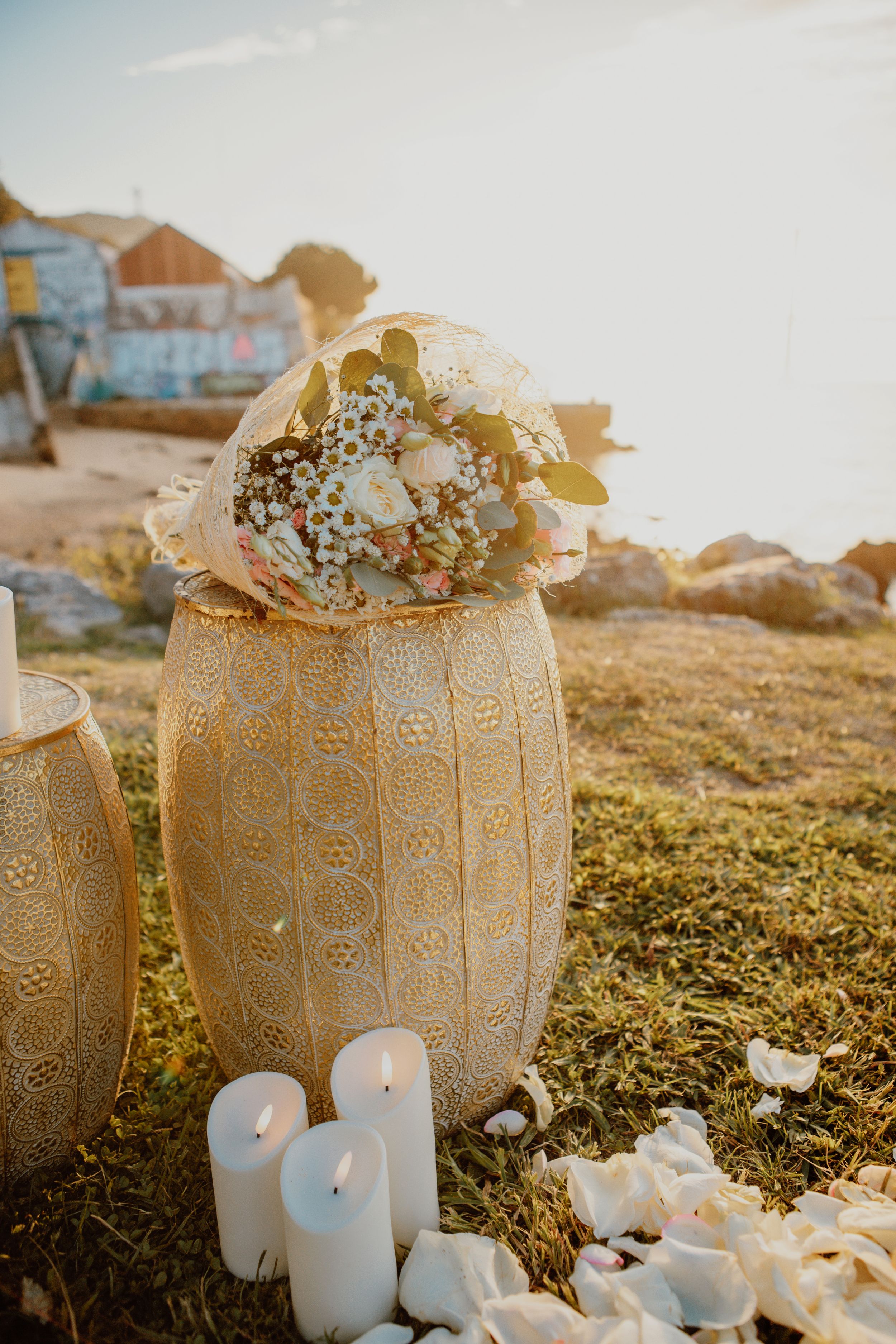 Rustic burlap pumpkin decorations filled with flowers and surrounded by glowing white candles at sunset.