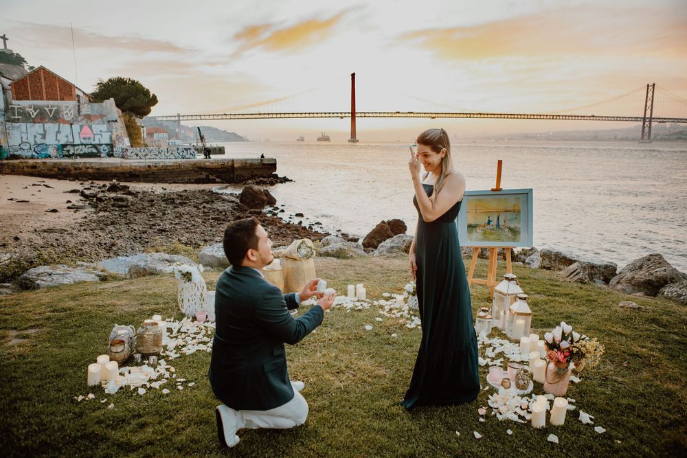 A romantic sunset proposal scene by the water with the Golden Gate Bridge visible in the background.