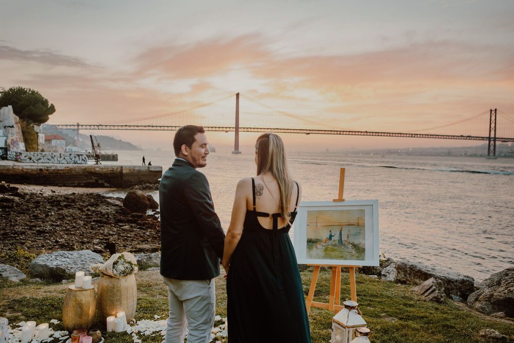 Romantic seaside picnic setup with candles and wine during golden hour by the San Francisco Bay.