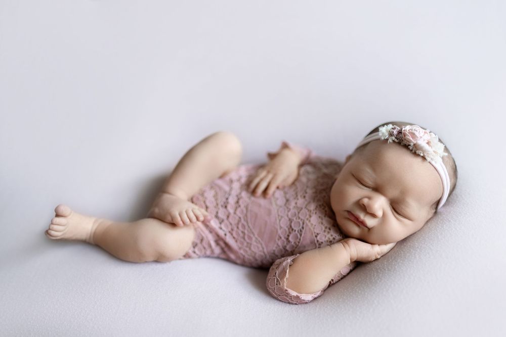 Artistic black and white photo series showing a sleeping newborn baby in different peaceful poses.