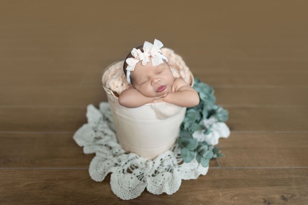 Delicate pink rose and dusty miller floral arrangement on a rustic wooden surface creates an elegant vintage aesthetic.