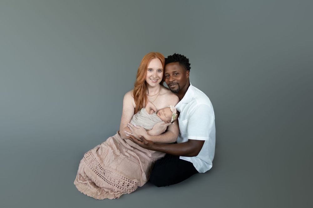A romantic maternity photo session featuring an intimate couple posing together in a studio setting.