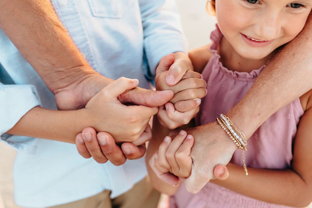 Close-up of hands joined together in a loving gesture on the beach.
