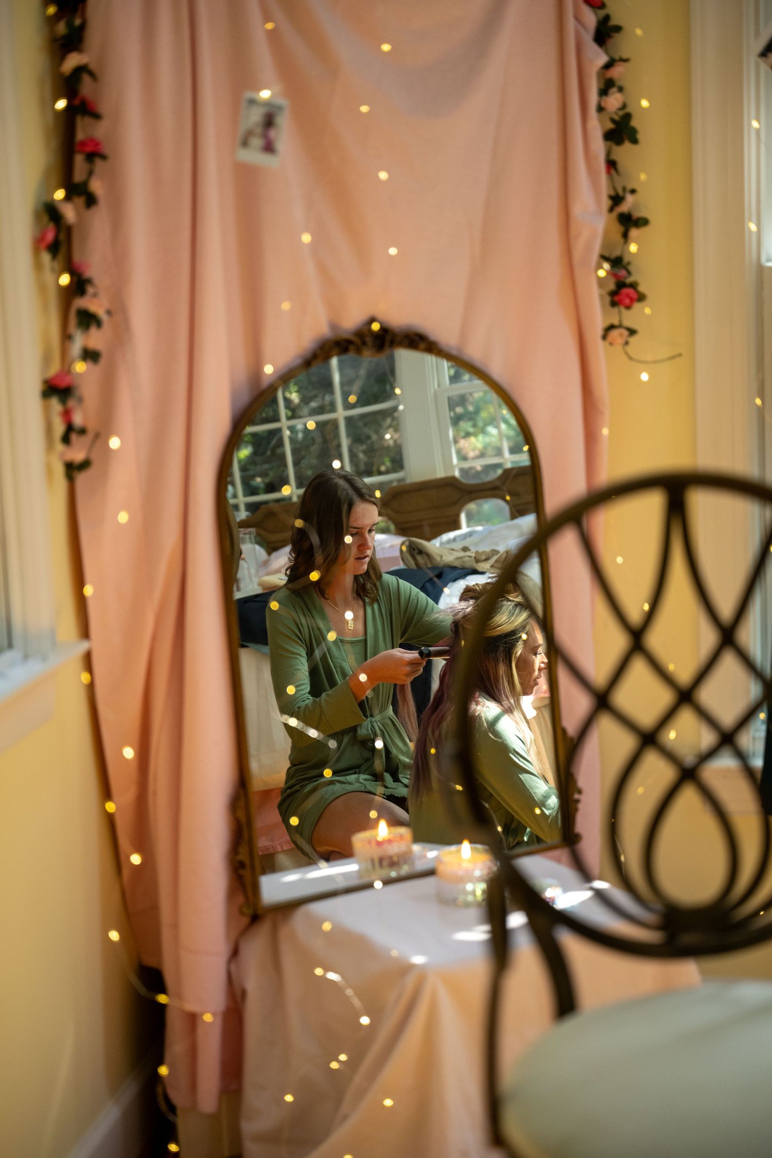 Wedding reception decor featuring string lights and blush pink fabric draping.