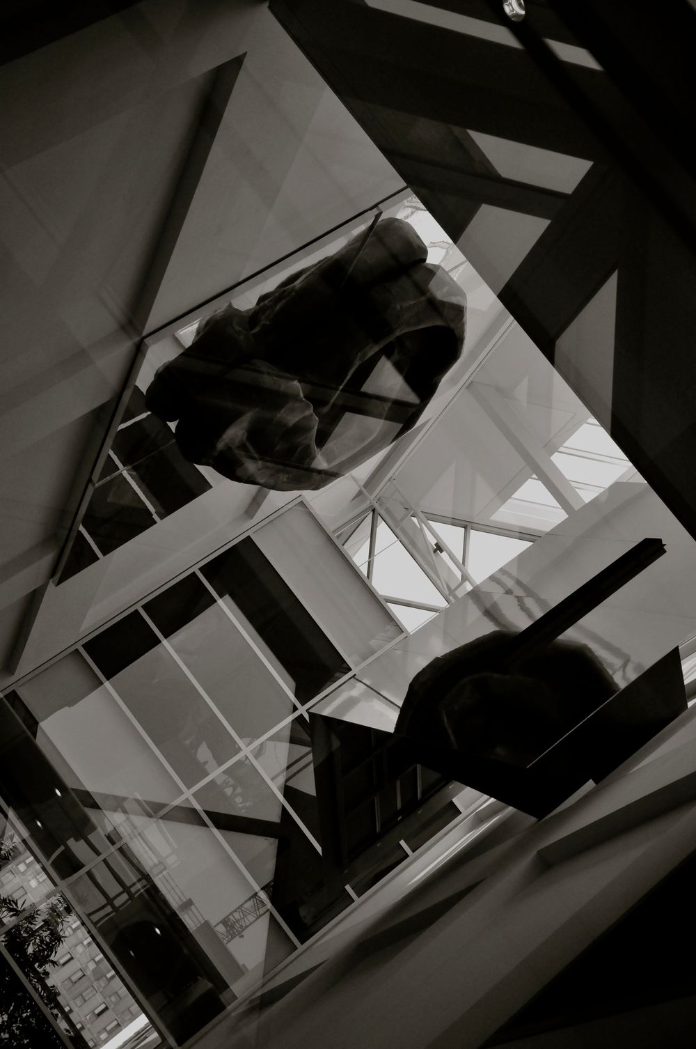 Black and white architectural photograph showing geometric shapes and reflections in a modern building interior.