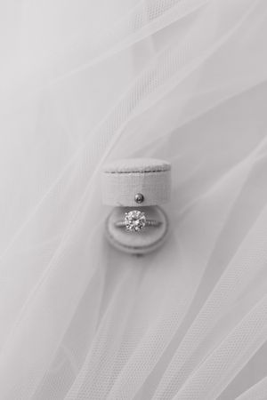 Diamond engagement ring nestled in layers of white tulle fabric.