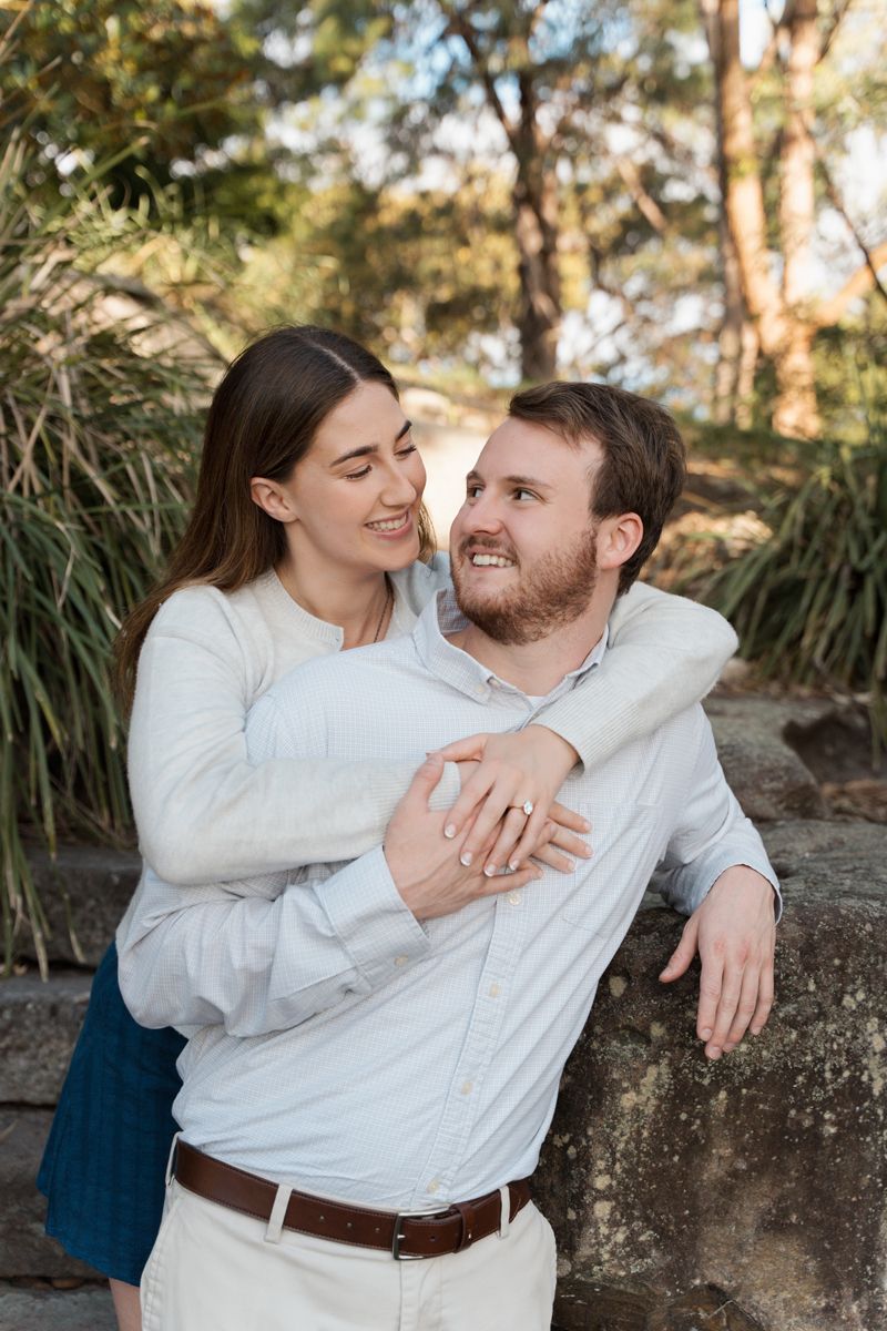 couple looking at each other after a proposal photoshoot in Sydney and showing off the ring