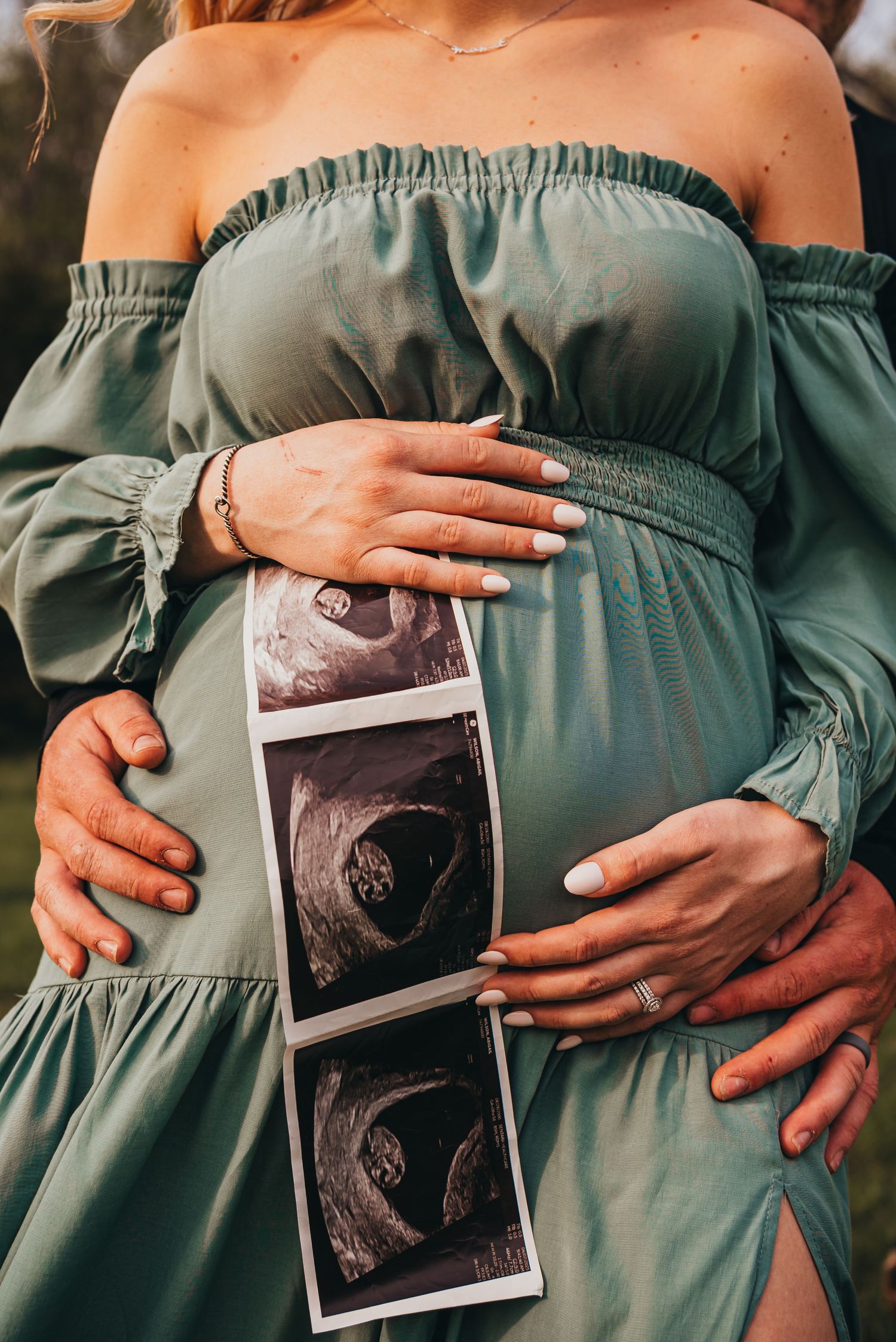 Close-up shots of a pregnant belly in a sage green dress holding ultrasound photos against the growing baby bump.