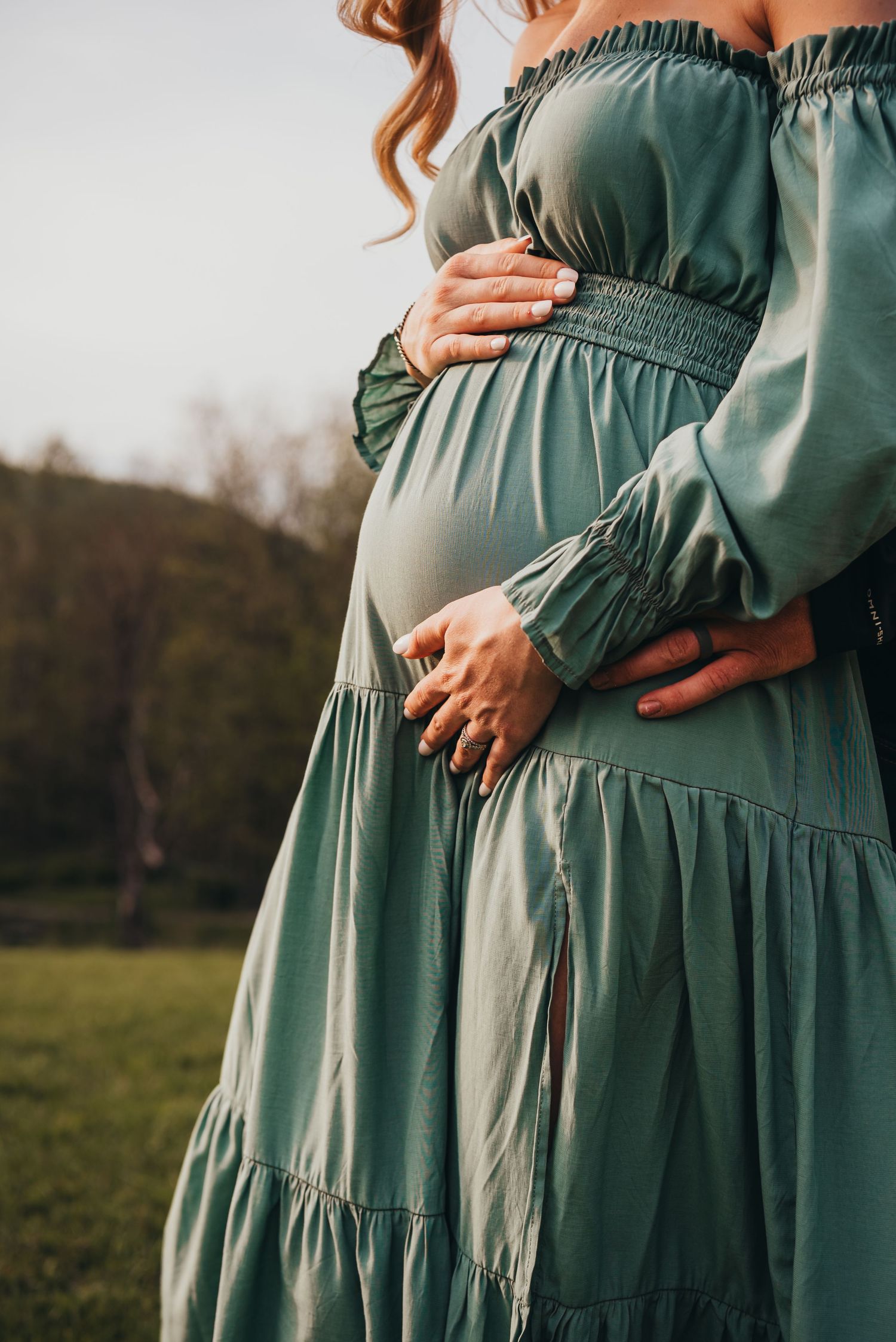 Progression of pregnancy photos showing a growing baby bump in a sage green maternity dress.