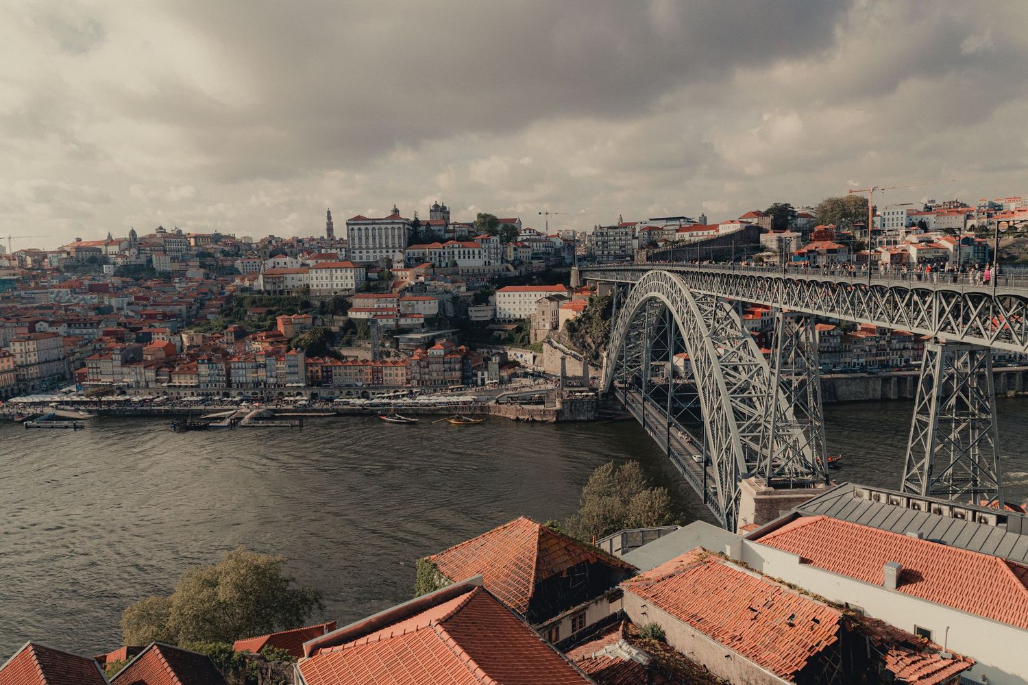 Panoramic view of Porto's historic cityscape with Dom Luis I Bridge and Douro River.