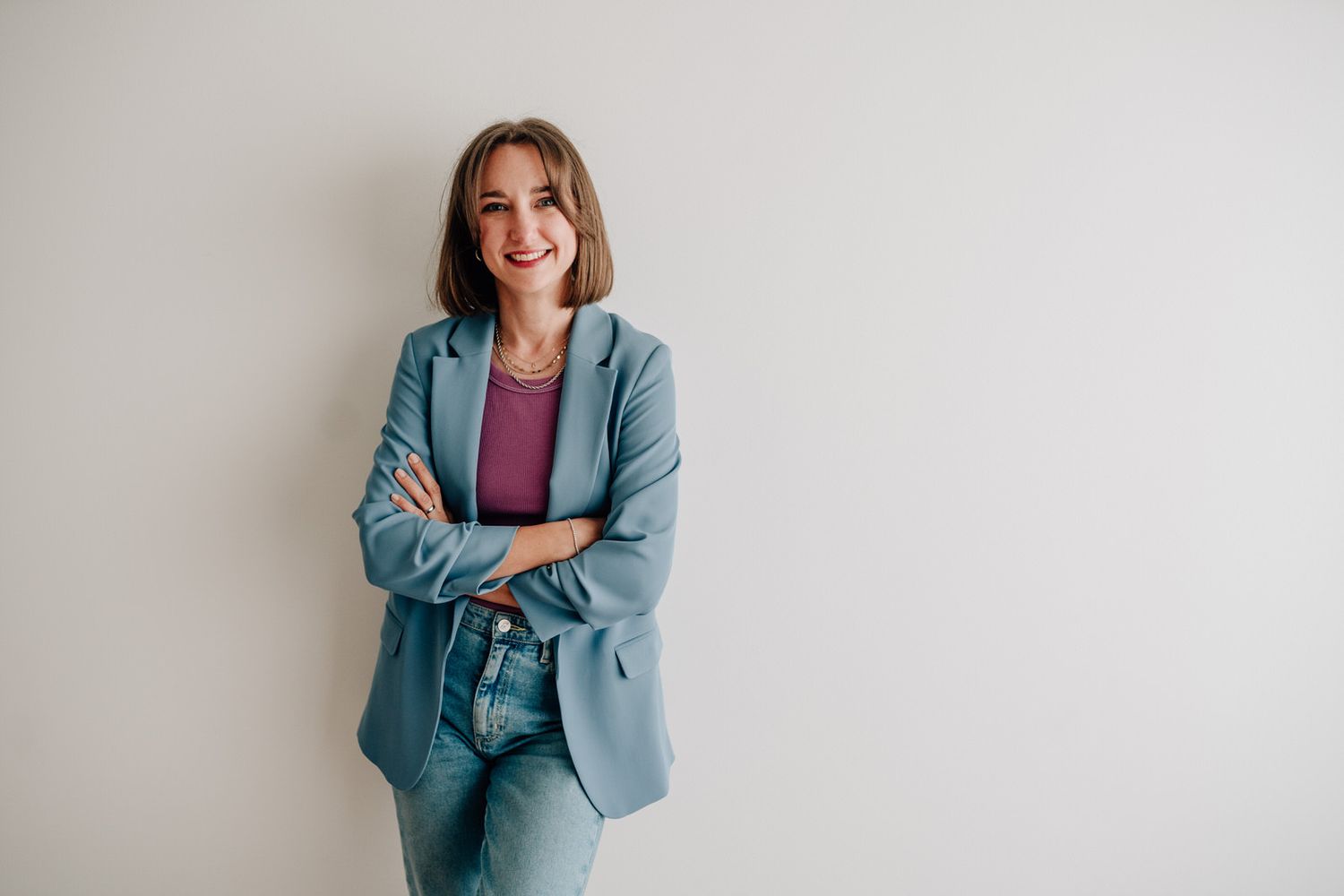 Professional in teal pantsuit posing confidently against white wall in modern setting.Business Portrait Rheinmain Frankfurt