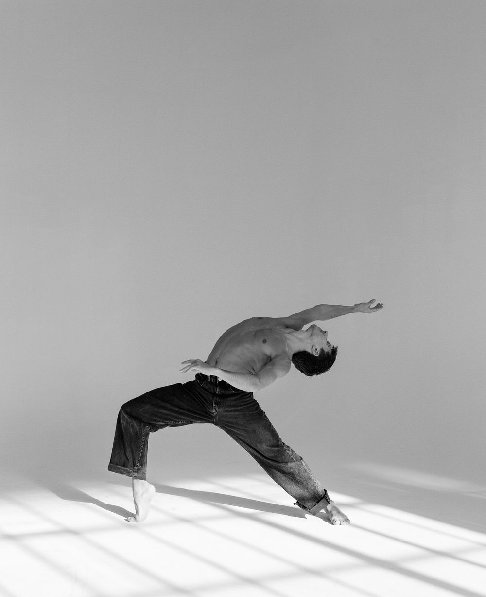 Artistic black and white photograph capturing dancer in dramatic backbend pose.