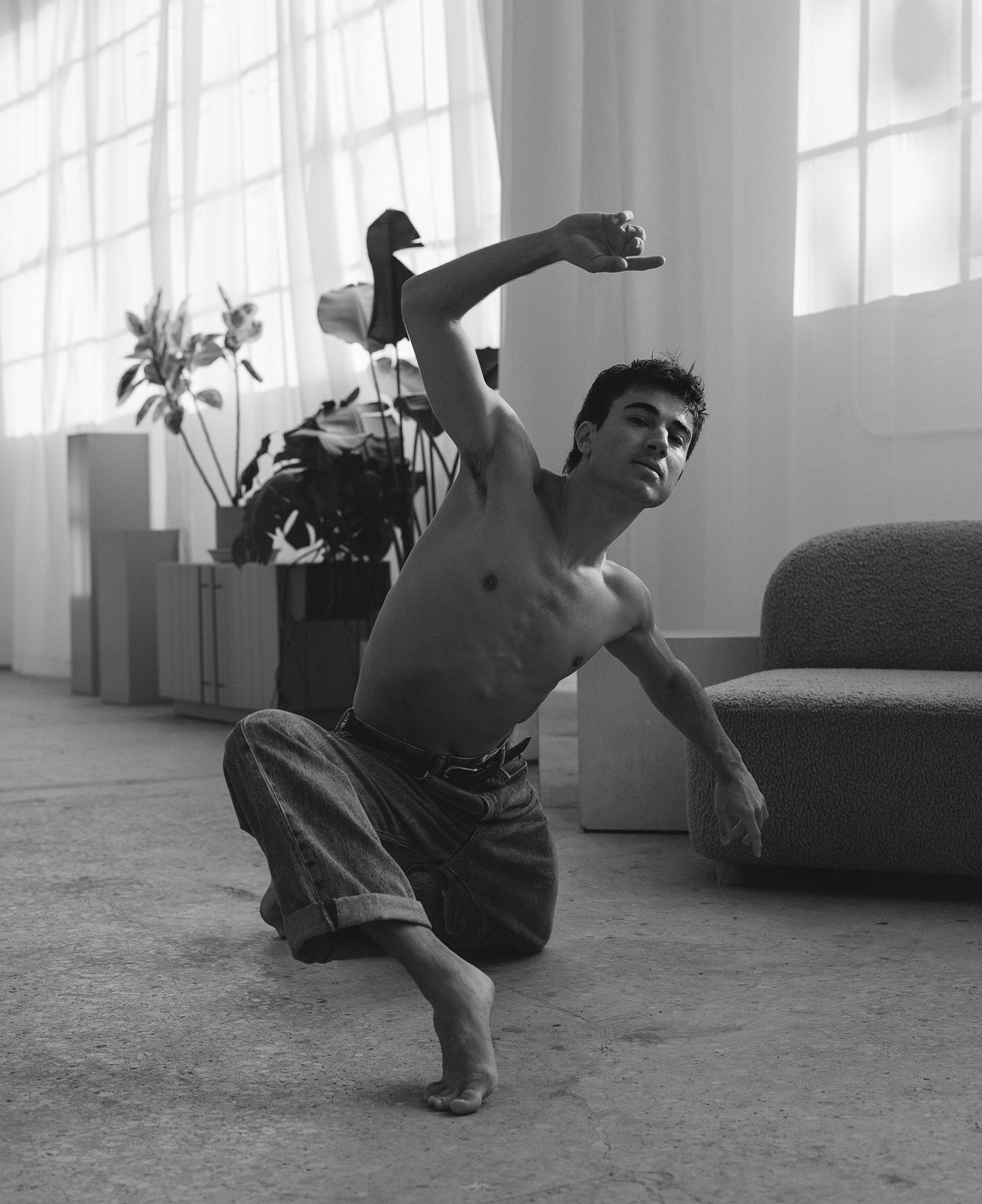 Expressive dance movement captured in sunlit studio with minimalist decor.