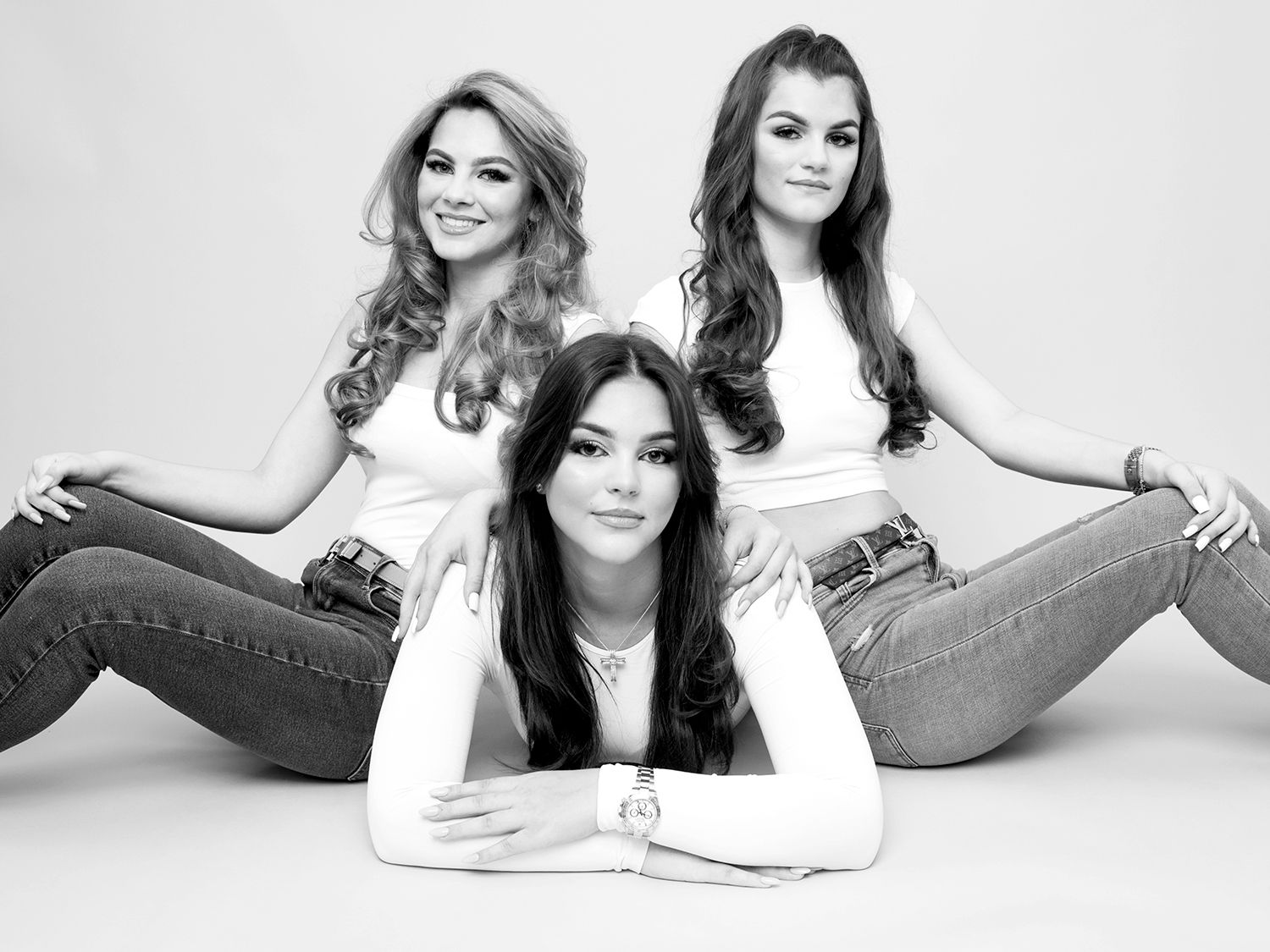 Family portrait featuring three women in jeans sitting on the floor, photographed by Abigail's Studio in Buckinghamshire.