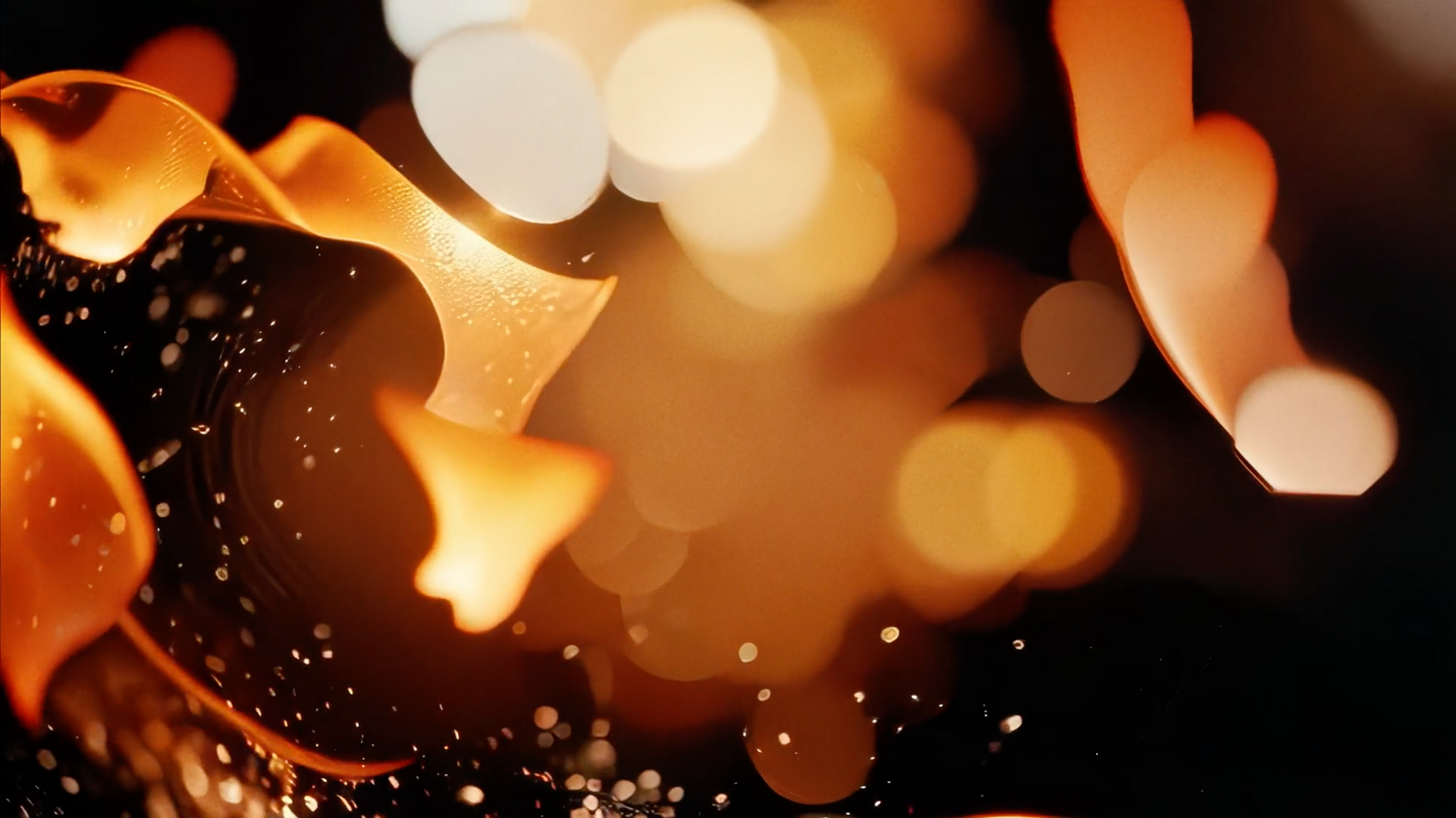 Abstract fire and sparks creating a magical bokeh effect against dark background.