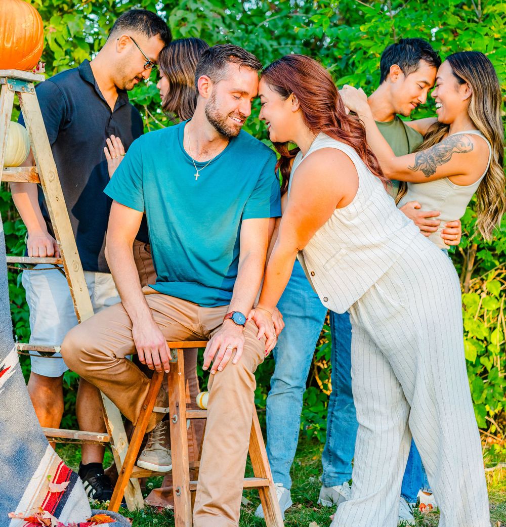 Three couples share intimate moments in a garden setting with pumpkins and a wooden ladder in the background.