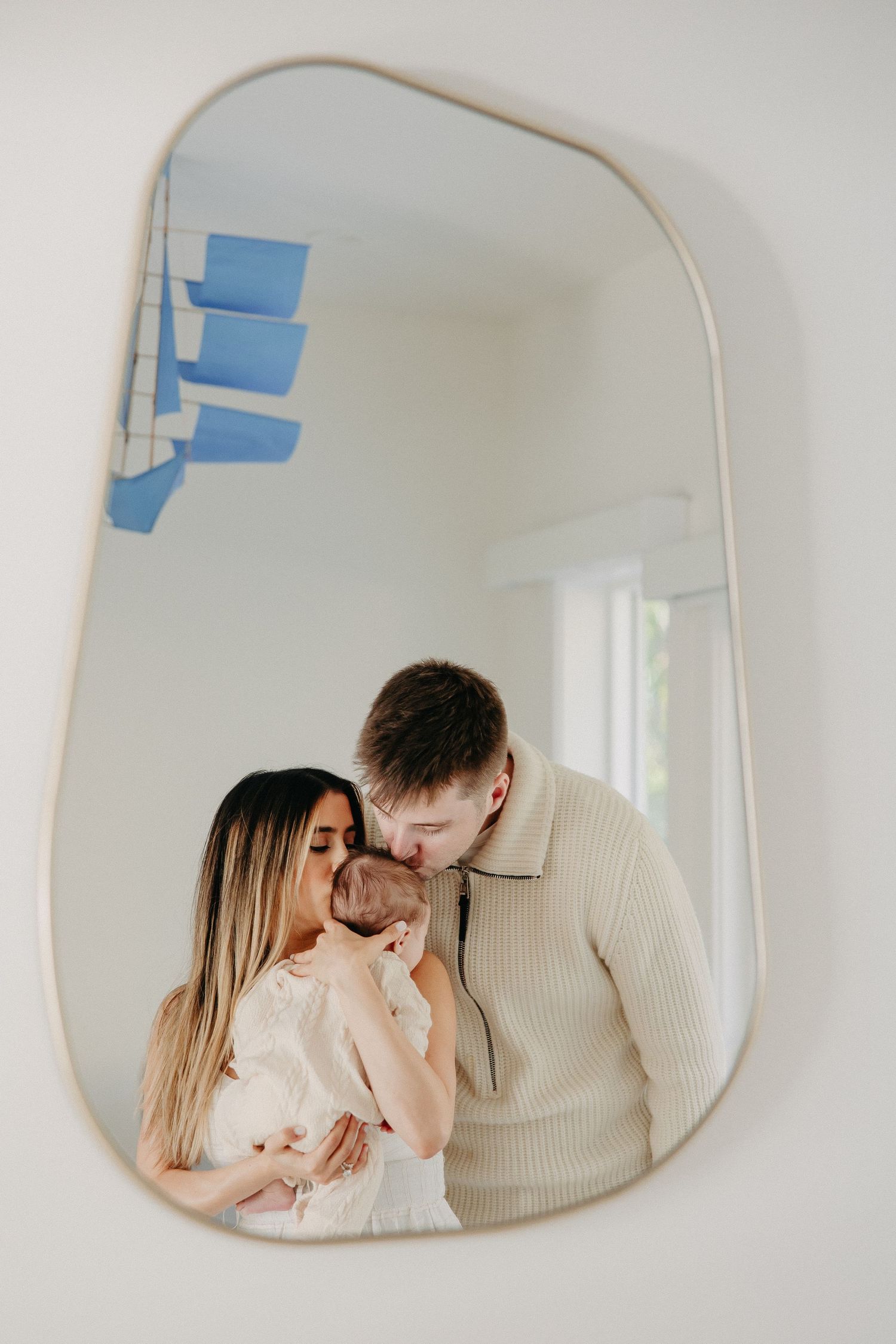 Mirror reflection showing tender romantic moment in soft beige tones with interior blue sticky notes visible above.