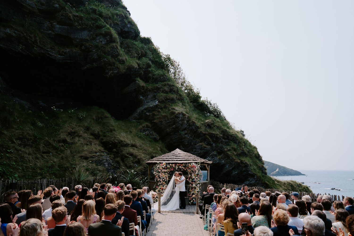 Bride and Groom first kiss during ceremony  at Tunnels Beach Wedding Venue in North Devon
