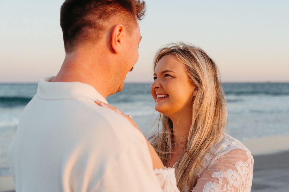 Couple sharing romantic moment on the beach at sunset, after surprise proposal. Wrightsville Beach, NC - Wilmington NC Couples Photographer