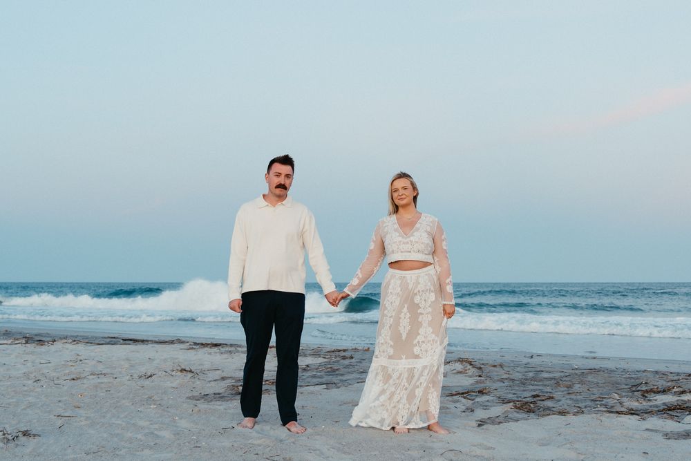 Couple holding hands on Wrightsville Beach, NC after just getting Engaged at Sunset. Wrightsville Beach Couples Photographer
