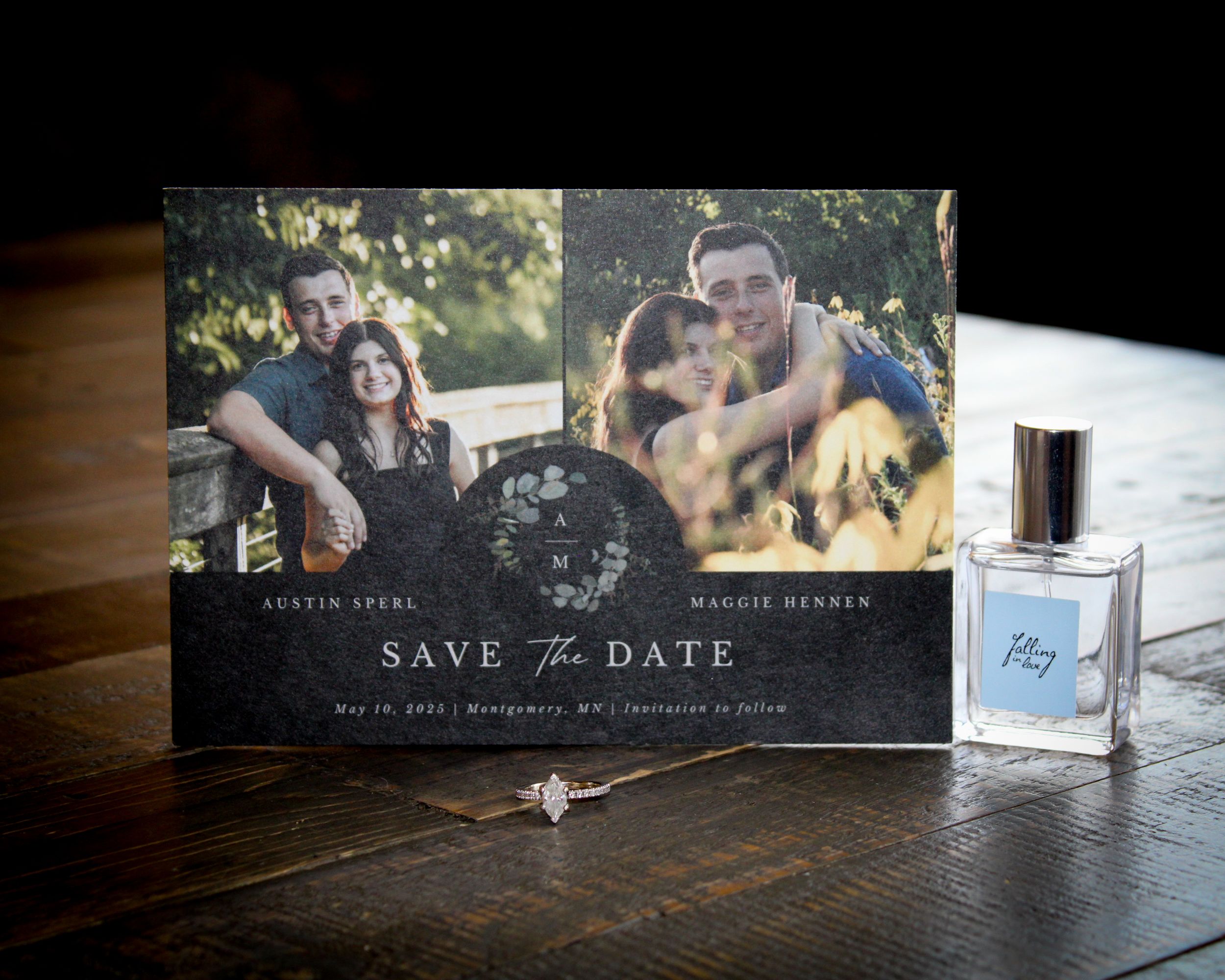 Save the date card with couple photos, ring, and perfume bottle on wooden table for Austin Spera and Maggie Henner.