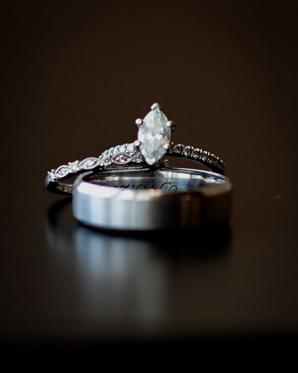 Elegant marquise diamond engagement ring with wedding band set displayed on dark background.