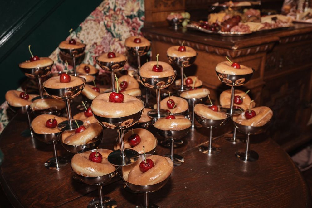 Elegant dessert display featuring chocolate cocktail glasses filled with caramel mousse topped with maraschino cherries.