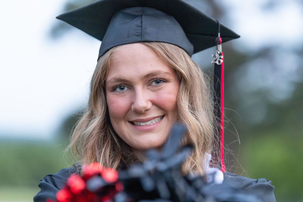 close up cap and gown senior portraits with pom poms, cheer, Rockwall, Texas photographer