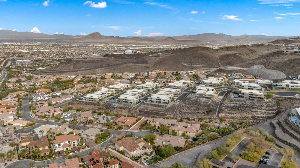 Aerial view of a Las Vegas residential community nestled against desert mountains with city views beyond.