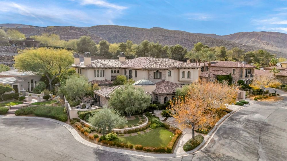 Grand Mediterranean luxury estate with manicured landscaping and mountain backdrop in Las Vegas, NV.