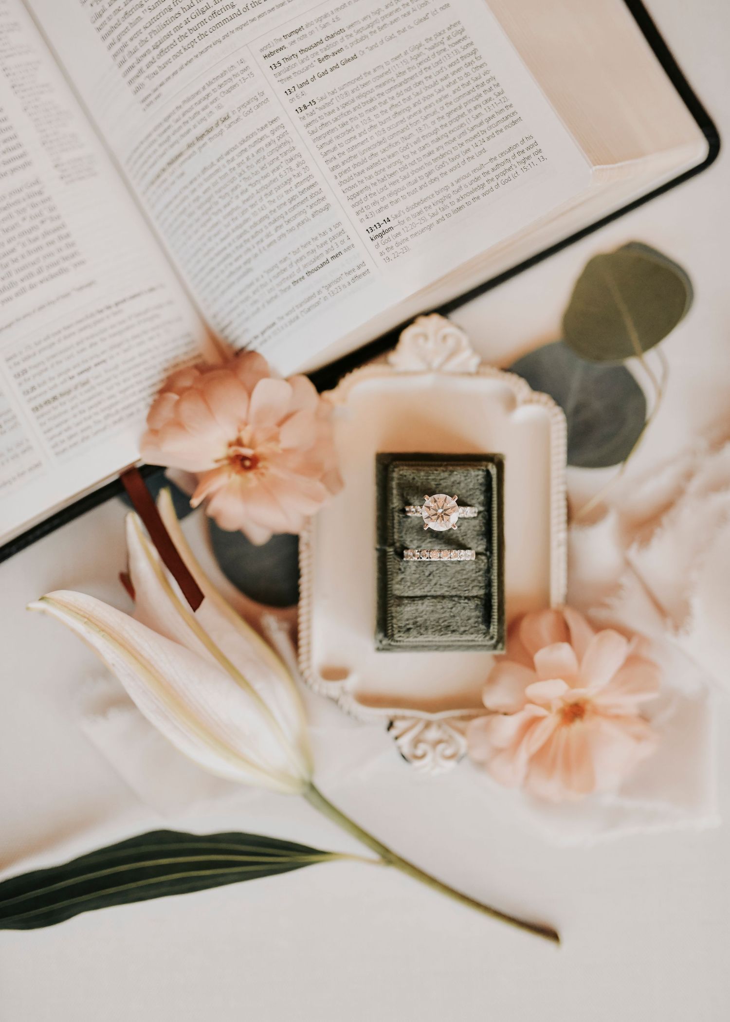 romantic bridal flat lay with soft blooms, rings, and invitation suite