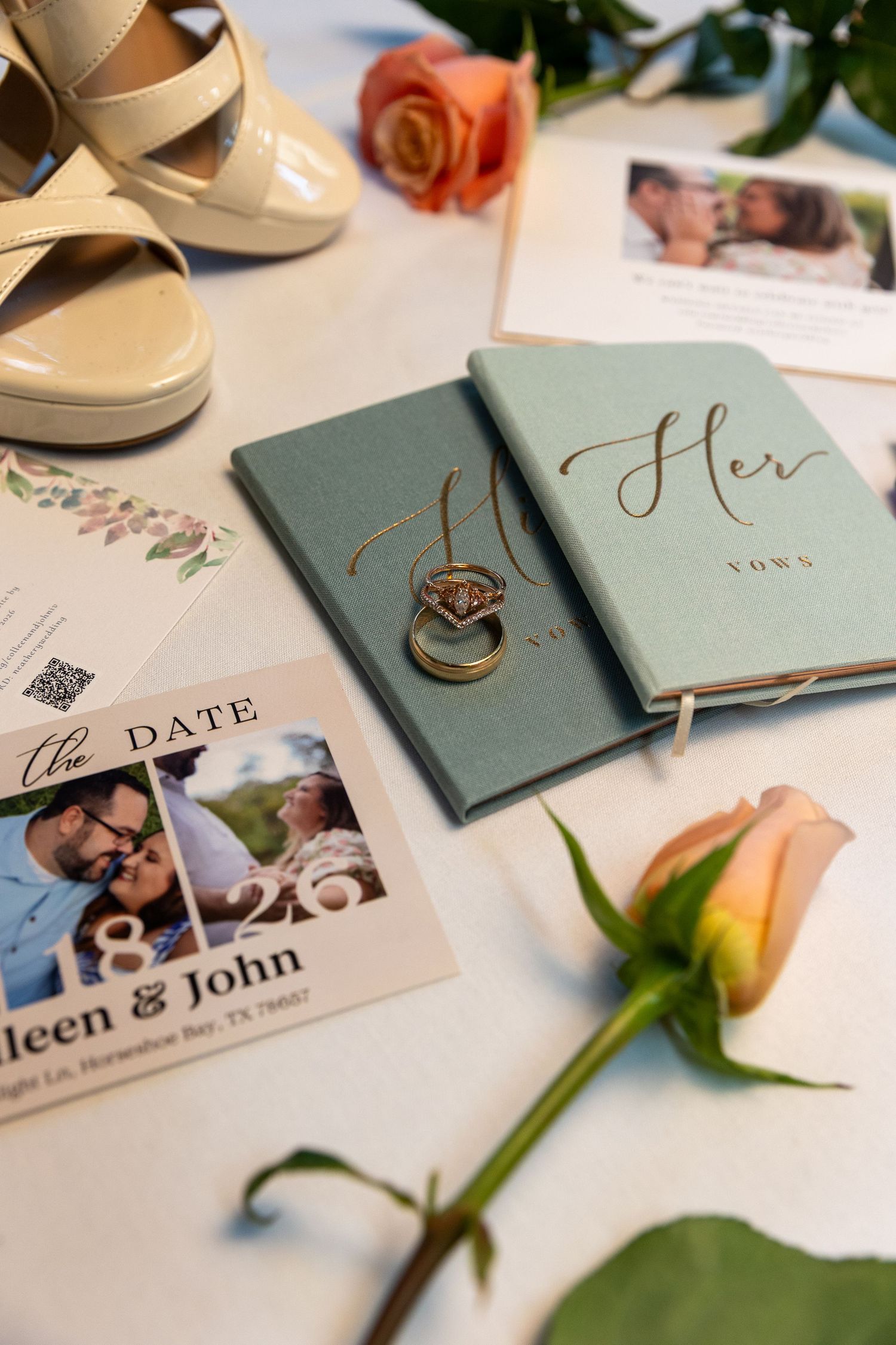 Elegant wedding flat lay featuring a bridal bouquet of blush roses, white heels, and a diamond ring in a wooden hexagonal box.