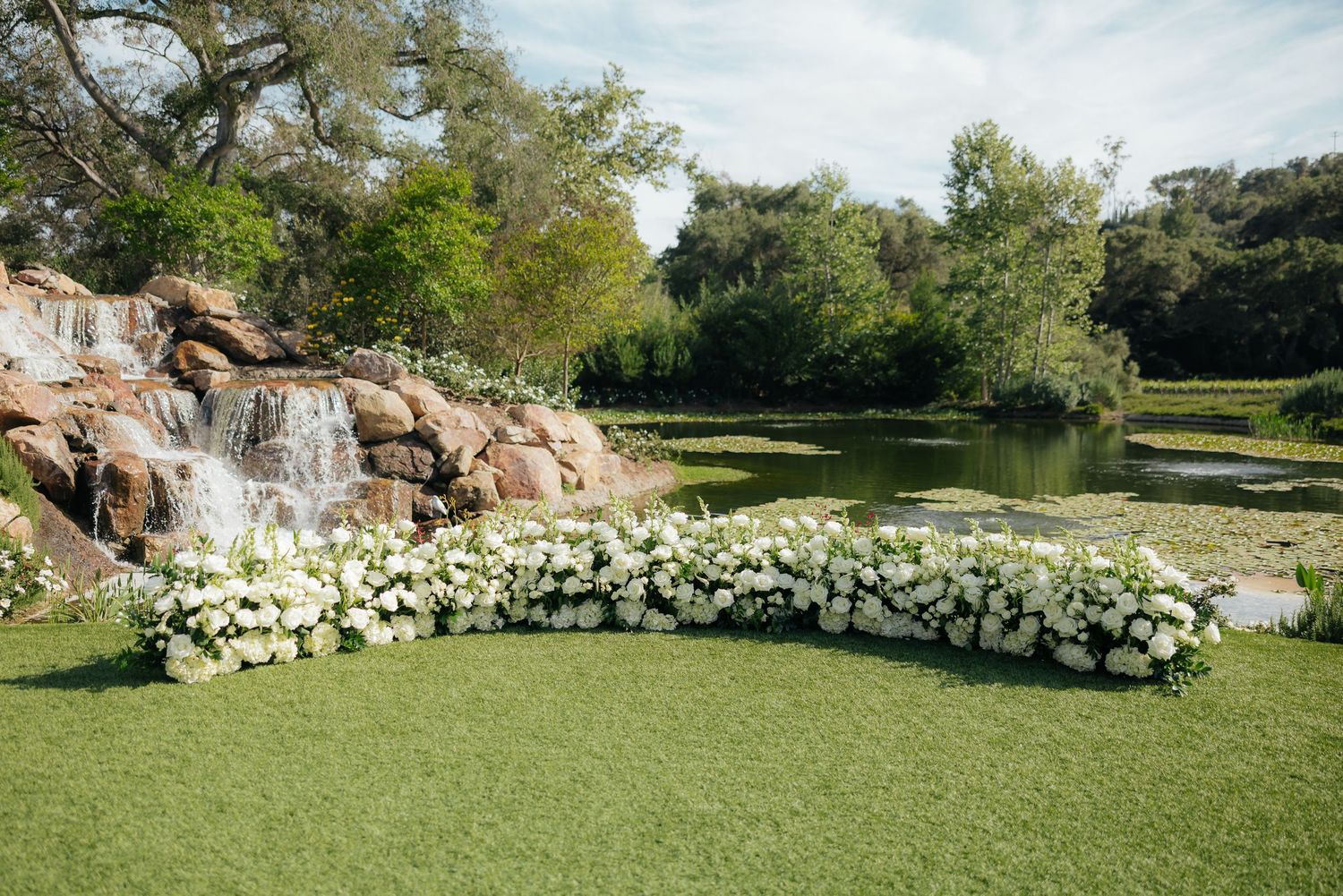Bridesmaids holding rustic woven baskets filled with elegant white and green floral arrangements at a wedding ceremony.