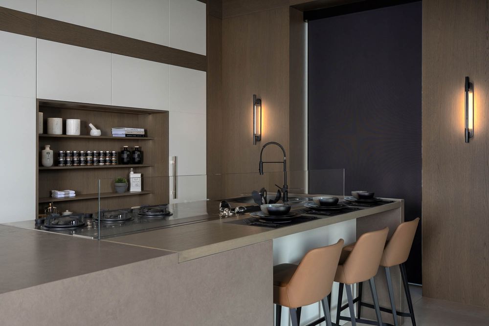 Modern kitchen interior with dark accent wall features sleek cabinetry, pendant lighting, and a minimalist design aesthetic.