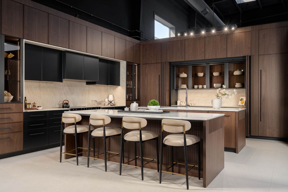 Modern bar area with sleek wooden paneling, white bar stools, and pendant lighting in an upscale restaurant interior.